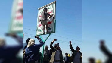 Yemenis tearing Houthi posters. (Supplied)