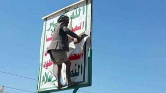 شاهد.. يمنيون يمزقون شعارات الحوثي في صنعاء