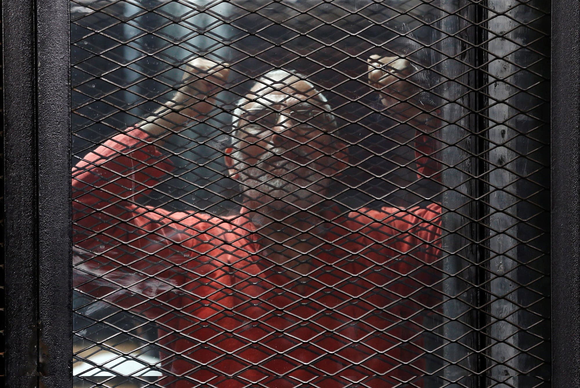 Muslim Brotherhood leader Mohamed Badie shouts solgans behind bars during trial at a court in Cairo on May 31, 2016. (Reuters)