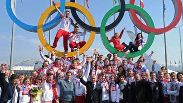 This file photo taken on February 24, 2014 shows Russia’s President Vladimir Putin (center) posing for a photo with Russian athletes, winners of the Sochi 2014 Winter Olympics. (AFP)