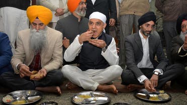 London Mayor Sadiq Khan (C) eats at a community kitchen as he visits the holy Sikh shrine of Golden temple in Amritsar, India. (Reuters)