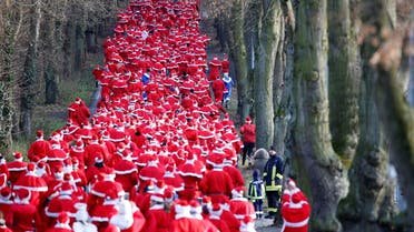 People dressed as Santa Claus run through the streets of Michendorf. (Reuters)