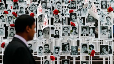 A man looks at photos of some of the people executed in Iran during a rally outside the UN headquarters in New York on Sept. 20, 2016. (AP)