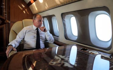 President Putin looks through the porthole while aboard the presidential plane during the approach to the Russian air base in Hmeimim on December 11, 2017. (AFP)