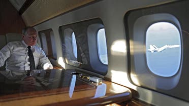 President Putin onboard a plane, with a Russian jet fighter seen through a window, as he travels to the Hmeymim air base in Syria December 11, 2017. (Reuters)