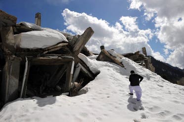 This March 20, 2011 photo shows a Pakistani man walking over part of the snow-covered destroyed 72-room hotel in the mountains of the Malam Jabba resort, 300 km northwest of Islamabad in the Swat Valley. (AFP)