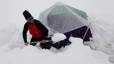 A German trekker removes snow from a kitchen tent at Concordia near the world’s second highest mountain K2 in the Karakoram mountain range in Pakistan on September 5, 2014. (Reuters)