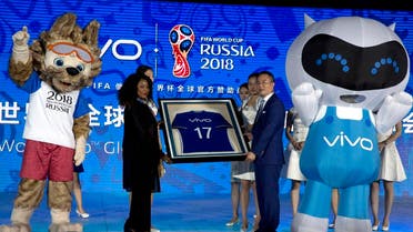Senior Vice President of Vivo, Ni Xudong, at right holds up a jersey with FIFA's Secretary General, Fatma Samoura during a ceremony to announce the Chinese smartphone brand Vivo's sponsorship of the FIFA soccer World Cup at the Imperial Ancestral Temple in Beijing, China, Wednesday, May 31, 2017. (AP)