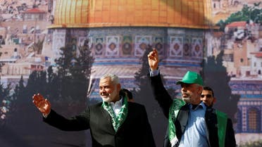 Hamas Chief Ismail Haniyeh and Gaza's Hamas Chief Yehya Al-Sinwar gesture to supporters during a rally marking the 30th anniversary of Hamas’ founding, in Gaza City on December 14, 2017. (Reuters)