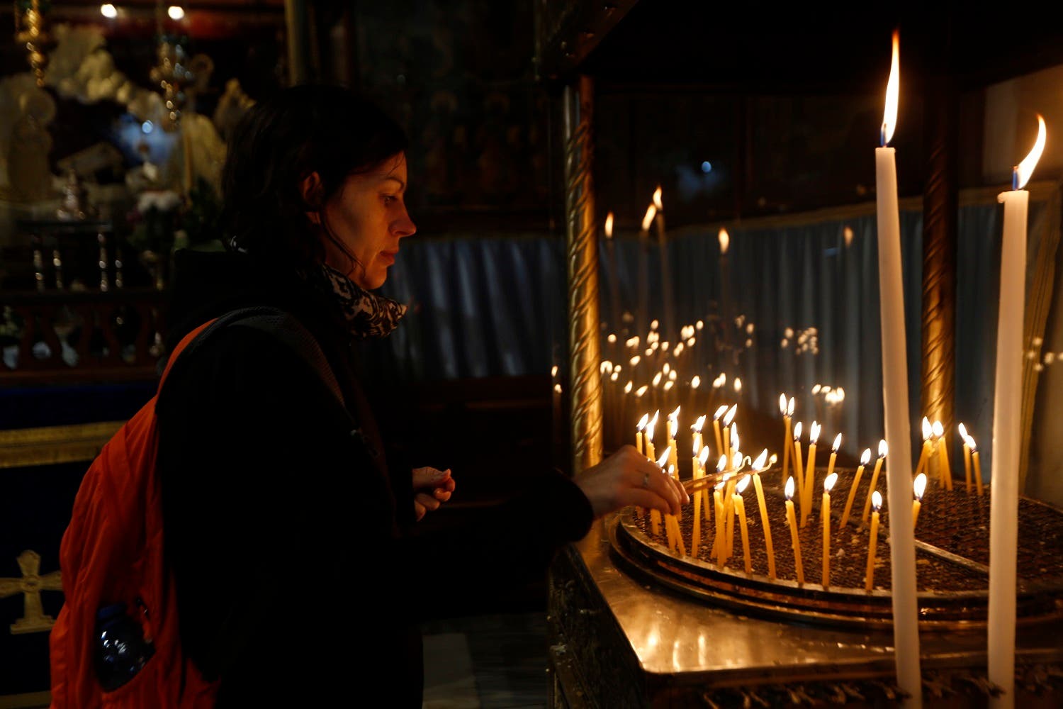 Christian worshiper lights candles at the Church of the Nativity, on Christmas Eve, in the West Bank City of Bethlehem, Sunday, Dec. 24, 2017. (AP)