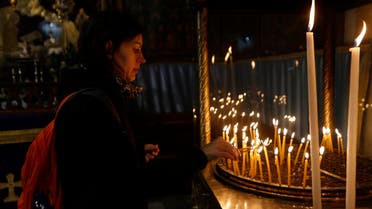 Christian worshiper lights candles at the Church of the Nativity, on Christmas Eve, in the West Bank City of Bethlehem, Sunday, Dec. 24, 2017. (AP) 