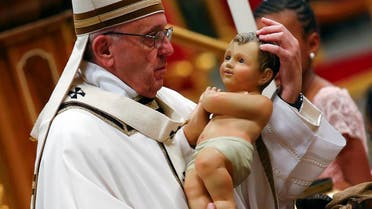 Pope Francis holds a statuette of baby Jesus during the traditional midnight mass in St. Peter's Basilica on Christmas Eve at the Vatican. (Reuters)