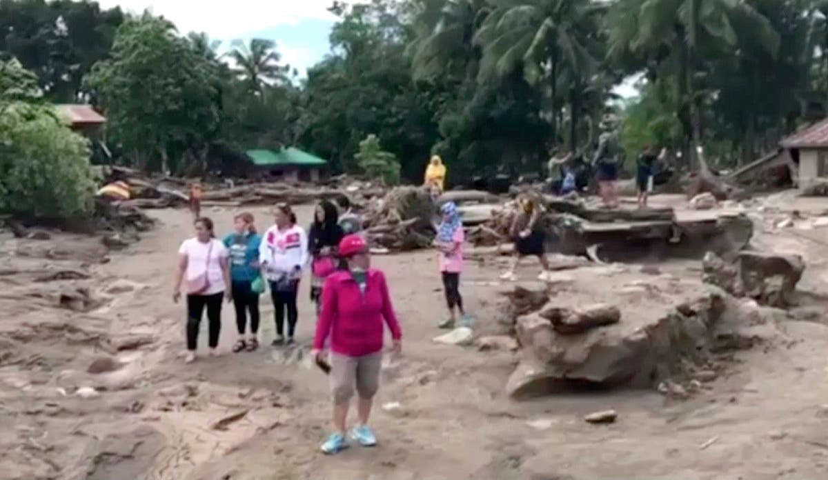 In this image made from video, people stand in the area damaged by storm and resulting floodwaters in Lanao del Norte, southern Philippines, Sunday, Dec. 24, 2017. (AP)