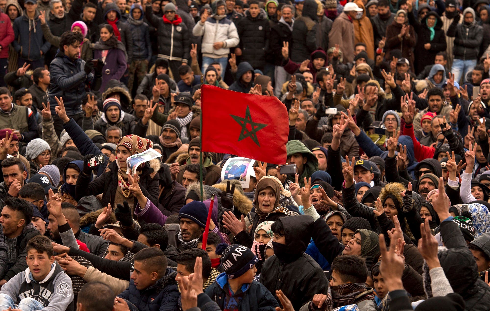 Moroccans shout slogans and wave their national flag as they participate in a demonstration after the funeral on December 27, 2017. (AFP)