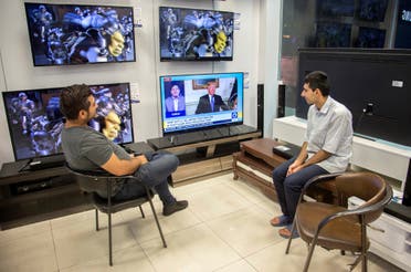 Men watch a television broadcast of US President Donald Trump’s speech, in Tehran on October 13, 2017. (Reuters)