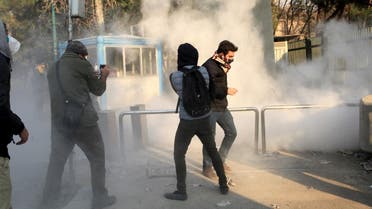 Iranian students run for cover from tear gas at the University of Tehran during a demonstration driven by anger over economic problems. (AFP)