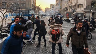 People are affected by tear gas fired by anti-riot Iranian police to disperse demonstrators in a protest over Iran's weak economy, in Tehran, Iran. (AP)