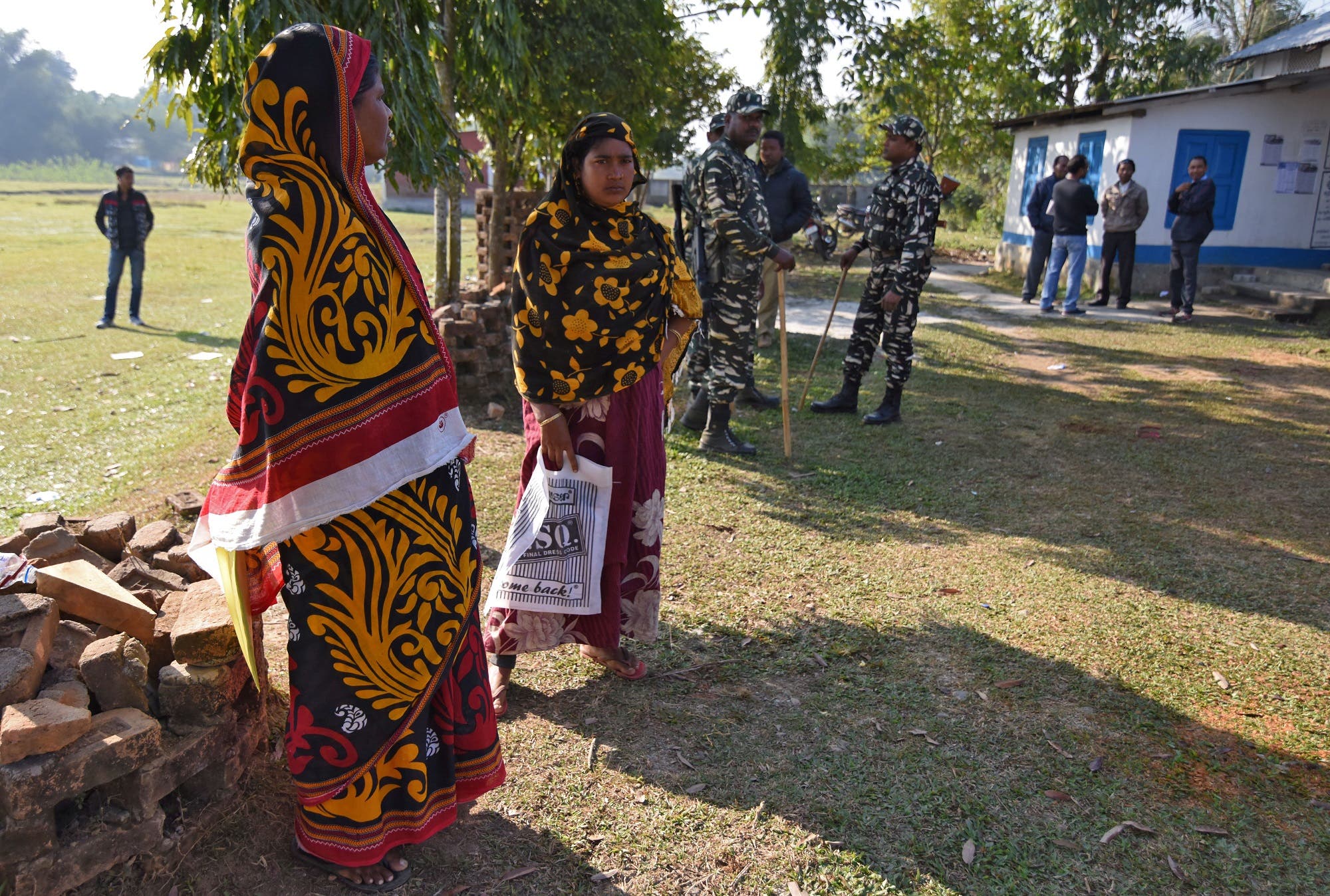 Women stand next to policemen as they wait to check their names on the draft list of the National Register of Citizens in Chandamari village of Goalpara district in Assam on January 2, 2018. (Reuters)