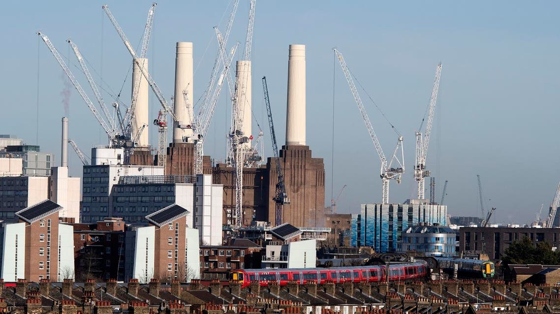 Passenger trains pass through Battersea Park rail station as construction work continues on the Battersea Power Station residential and retail development complex in south-west London on December 18, 2017. (AFP)