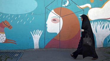 A woman walks past a mural in downtown Tehran, Iran, Wednesday, Jan. 3, 2018. (AP)