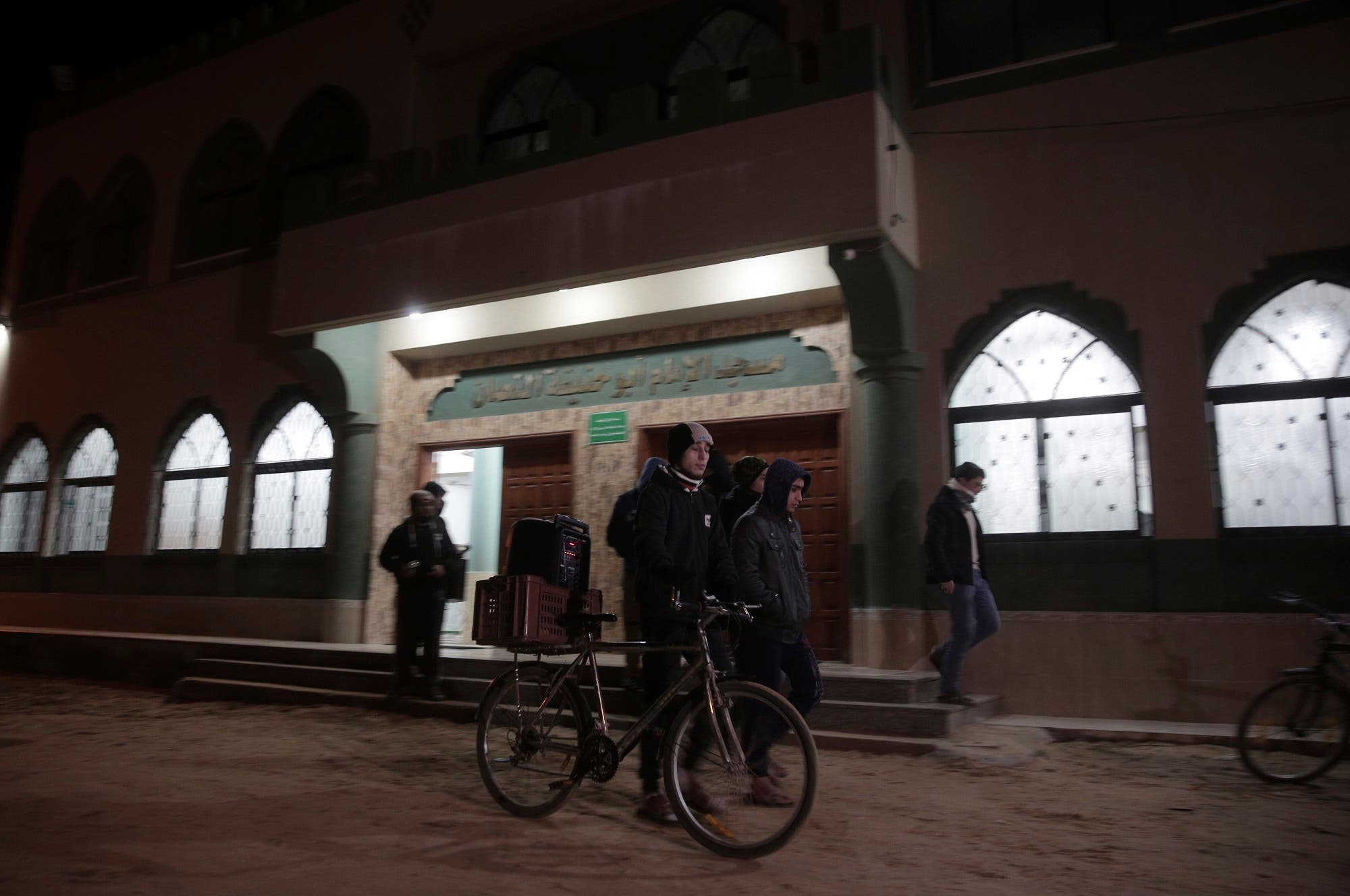 In this Wednesday, Jan. 3, 2018 photo, Palestinian volunteers walk with a portable sound system calling people to wake up for the dawn prayer in Gaza City. (AP)