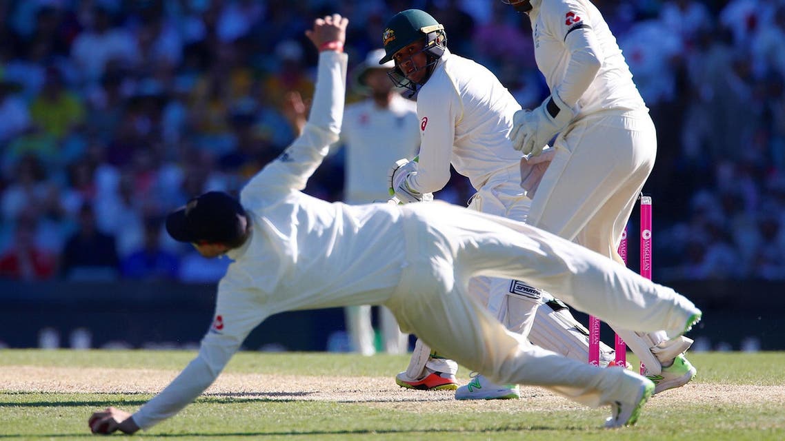 Australia’s Usman Khawaja watches England’s captain Joe Root dive to stop the ball during the second day of the fifth Ashes cricket test match. (Reuters)