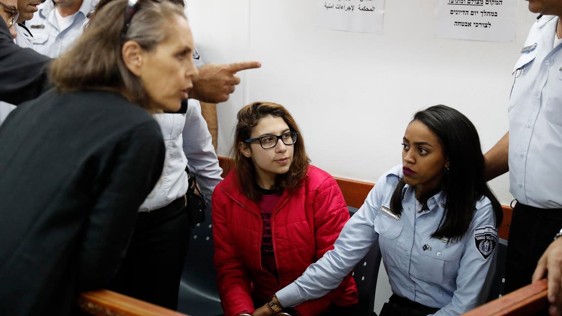 Nour Tamimi (C) who is being detained after a viral video showing her with two members of her family allegedly assaulting two Israeli soldiers is seen in a military court at the Israeli-run Ofer prison in the West Bank village of Betunia on December 28, 2017. The Tamimi family are at the forefront of regular protests in Nabi Saleh, a frequent scene of demonstrations against Israel's occupation of the West Bank. AHMAD GHARABLI / AFP