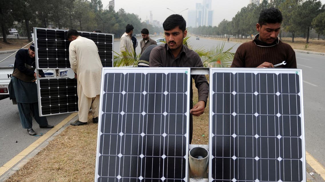 Pakistani workers prepare solar energy light panels in Islamabad on February 2, 2014. (AFP)