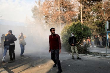 University students attend a protest inside Tehran University while a smoke grenade is thrown by anti-riot Iranian police. (AP)