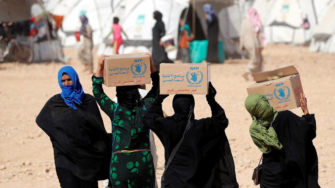 People displaced from fightings between the Syrian Democratic Forces and Islamic State militants carry boxes of food aid given by UN's World Food Programme at a refugee camp in Ain Issa, Syria October 10, 2017. (Reuters)