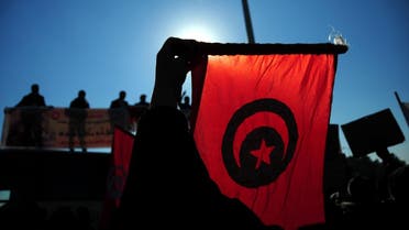 Tunisian police officers wave the national flag and posters as they demonstrate outside the presidential palace in Carthage near Tunis. (AP)