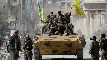 Fighters of Syrian Democratic Forces ride atop of an armored vehicle after Raqqa was liberated from ISIS militants, in Raqqa, on October 17, 2017. (Reuters)