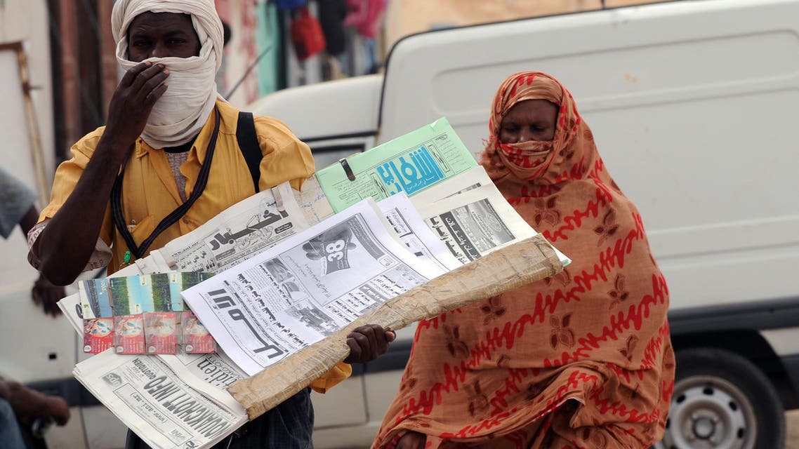 A newspaper seller is followed by a woman on October 6, 2008 in Nouakchott. The leadership has categorically refused international demands for the reinstatement of the president, saying it would not move backwards. The ousted president Sidi Ould Cheikh Abdallahi was the country's first democratically elected president. AFP PHOTO/SEYLLOU SEYLLOU DIALLO / AFP