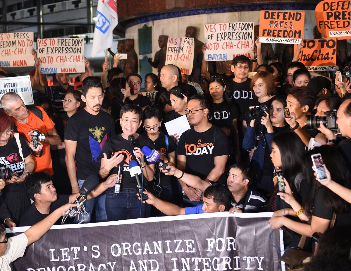 Maria Ressa (centre L-with microphone), the CEO and editor of online portal Rappler, speaks during a protest on press freedom along with fellow journalists in Manila. (AFP)