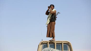 A tribal fighter loyal to Yemen’s government stands on the roof of a pick-up truck as he uses binoculars to look at Houthi positions between al-Jawf and Marib on December 5, 2015. (Reuters)