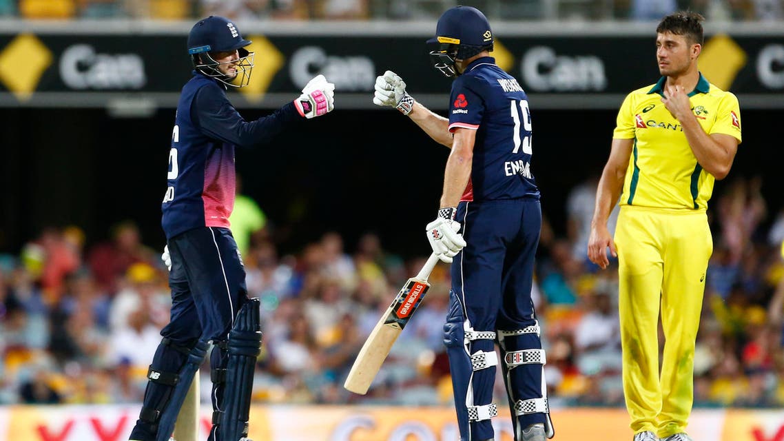 England’s Joe Root (left) and Chris Woakes (center) celebrate victory as Australia’s Marcus Stoinis looks on, during the ODI cricket match between England and Australia in Brisbane on January 19, 2018. (AFP)