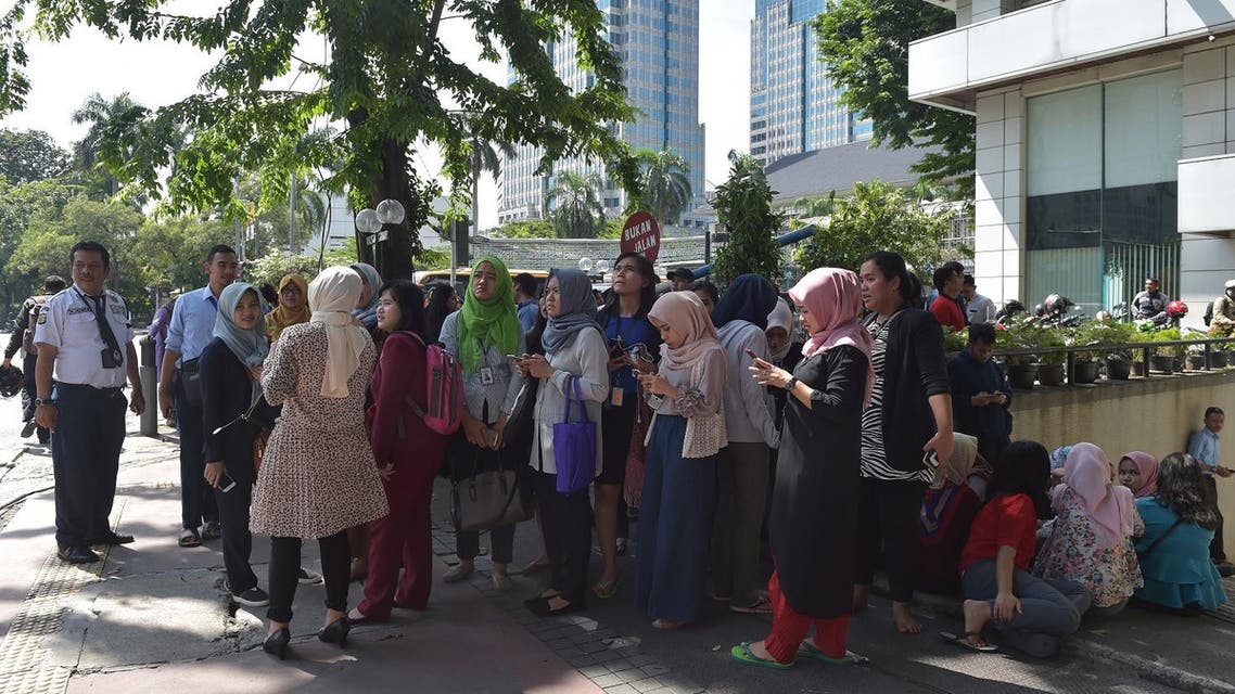 Indonesians wait outside an office building after a 6.4 magnitude quake hit Jakarta on January 23, 2018. (AFP)
