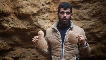 Abdul Karim al-Kafarnah, a Palestinian resident of Beit Hanun, holds a pottery fragment at a freshly-discovered cemetery in the garden of his house in the town in the northern Gaza Strip, on January 26, 2018. (AFP)