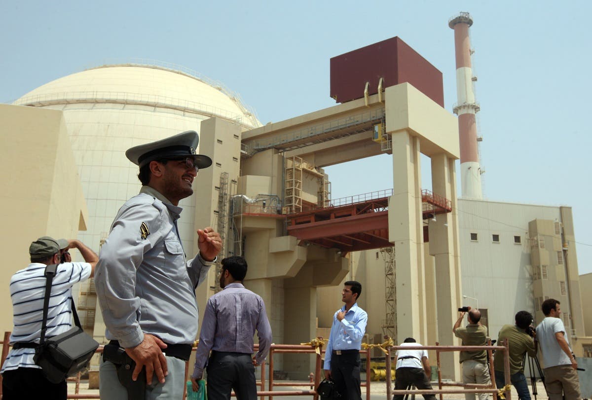 An Iranian security man stands next to journalists outside the reactor building at the Russian-built Bushehr nuclear power plant in southern Iran on August 21, 2010 during a ceremony initiating the transfer of Russia-supplied fuel to the facility after more than three decades of delay. AFP PHOTO/ATTA KENARE ATTA KENARE / AFP