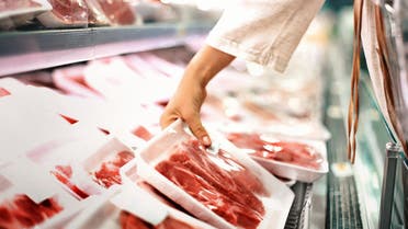 Buying meat at a supermarket. - Stock image... 