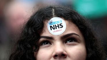 A demonstrator displays a sticker on her forehead during a protest march highlighting opposition to the government’s health policy, in central London, on February 3, 2018. (Reuters)