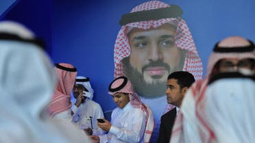 Saudi men chat in front of a poster of Saudi Crown Prince Mohammed bin Salman in Riyadh. (Photo: AFP)