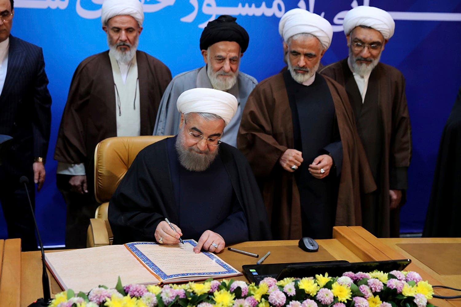 President Hassan Rouhani signs the document of Iran’s “Charter of Citizenship Rights” in Tehran on Dec. 19, 2016. (Iranian Presidency Office via AP)