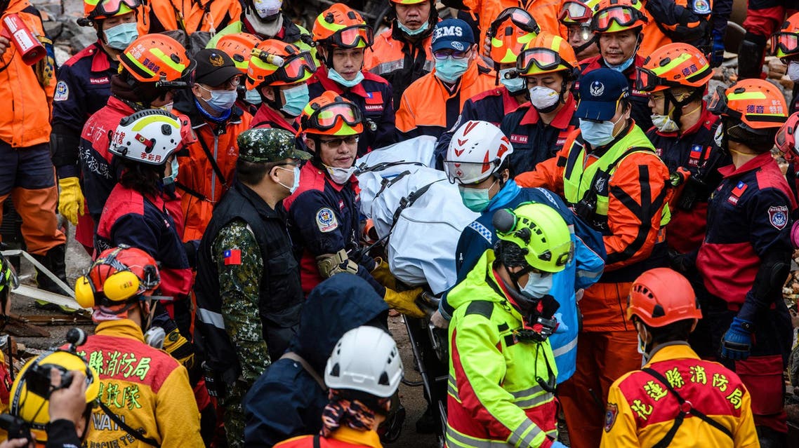 Rescue workers recover the body of a hotel worker from a building leaning at a precarious angle, in Hualien on February 8, 2018. (AFP)