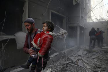 A man holds a child after an airstrike in the besieged town of Douma on February 7, 2018. (Reuters)
