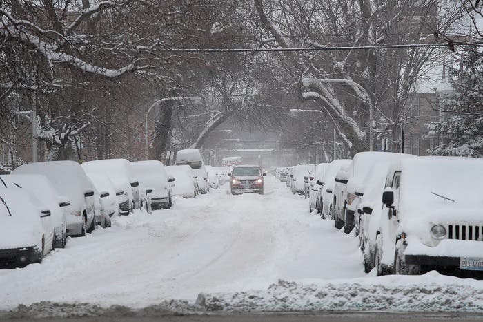 A motorist works his way down a snow-covered street after more than 7 inches of snow fell on February 9, 2018 in Chicago, Illinois. (AFP)