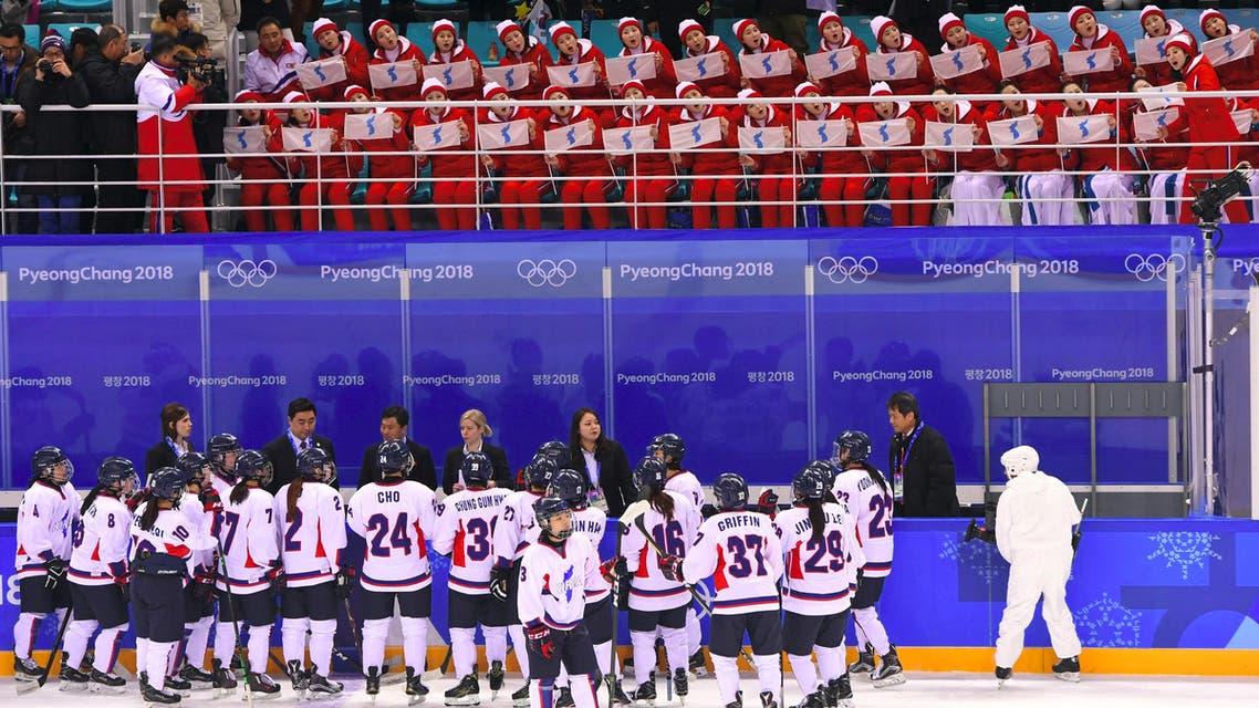 Unified Korea's team gather under the tribunes where North Korea's cheeleaders are seated during the women's preliminary round ice hockey match between Switzerland and the Unified Korean team during the Pyeongchang 2018 Winter Olympic Games at the Kwandong Hockey Centre in Gangneung on February 10, 2018. Brendan Smialowski / AFP
