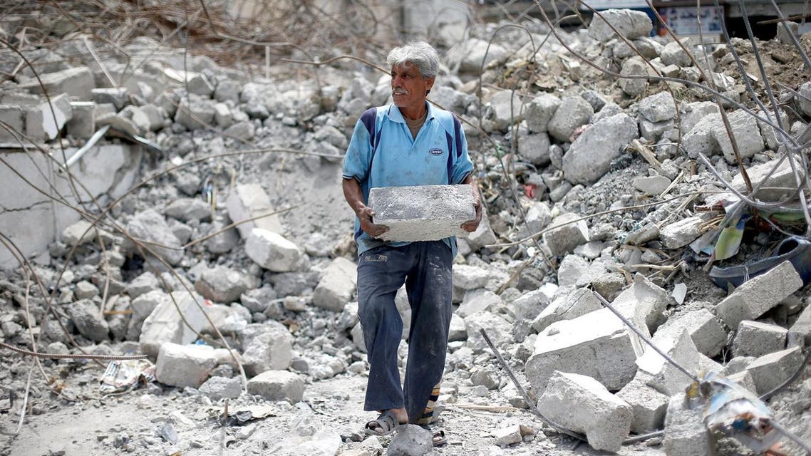 A worker removes rubble during the rebuilding of a building destroyed during fighting between Iraqi forces and ISIS fighters, eastern Mosul. (Reuters)