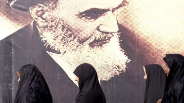 Iranian women walk past a poster of Iran's late leader Ayatollah Ruhollah Khomeini during the anniversary ceremony of Iran's Islamic Revolution in Behesht Zahra cemetery, south of Tehran, February 1, 2016. (Reuters)