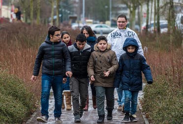 Primary school teacher Stefan Gesk (Back R) and Syrian teaching assistant Hend Al Khabbaz (Back C) take young Syrian refugee pupils (all except child on L) on an outdoor project near the Sigmund-Jaehn-Grundschule (primary school) in Fuerstenwalde, eastern Germany. (AFP)